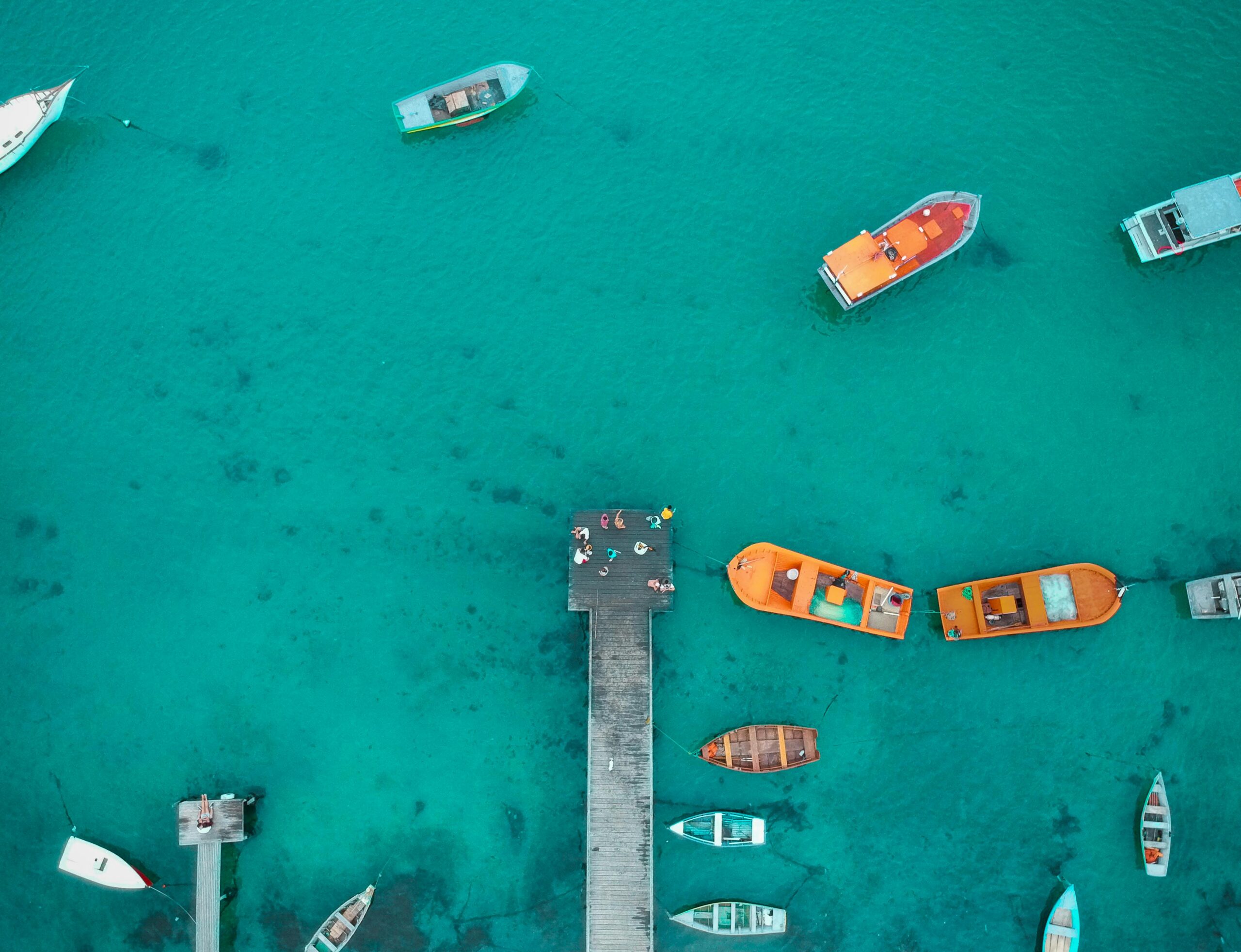 An aerial view of small boats and a dock on the water.